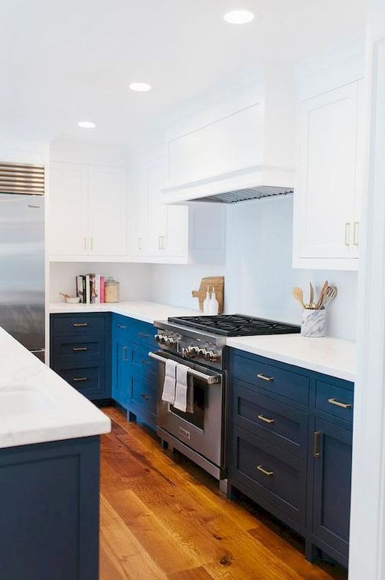 A bold blue and white mid century modern kitchen with white countertops and a metal cooker