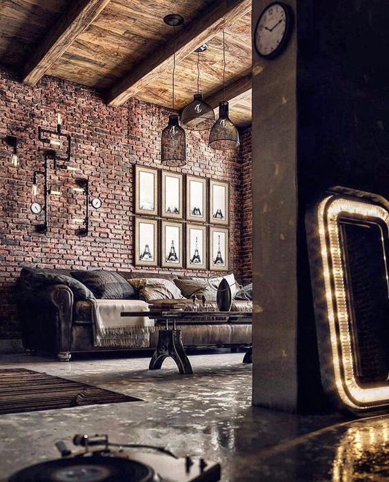 a catchy industrial vintage living room with brick walls, a wooden ceiling, exposed piping, pendant lamps and catchy industrial furniture