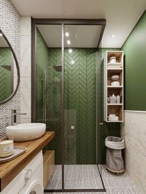 a chic grass green and neutral bathroom with printed tiles, a wooden vanity and a glass enclosed shower space