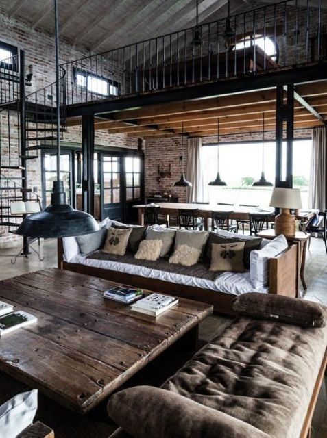 a chic industrial living room with brick walls, a wooden table, metal lamps and comfy wooden and upholstered furniture