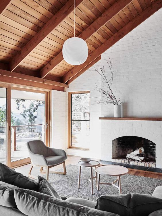 a chic modern farmhouse living room with white brick walls and a fireplace clad with the same brick looks veyr cool