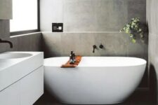 a contemporary bathroom with large scale tiles, an oval tub, a floating vanity, potted greenery is super chic