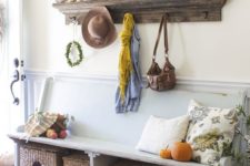 a cozy fall farmhouse entryway with a shabby chic bench, a stained open shelf, basket boxes for storage and candles
