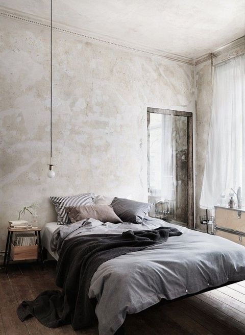 a cozy industrial bedroom with shabby chic walls, a floating bed, wooden nightstands and a dresser