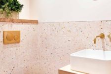 a cute blush bathroom with painted and terrazzo tile walls, white appliances and gold fixtures looks pretty, cute and very chic