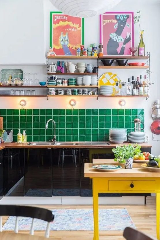 a glossy black kitchen with butcherblock countertops and an emerald tile backsplash and a yellow kitchen island for a lovely look