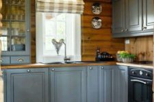 a grey farmhouse kitchen with wooden countertops and a backsplash, with plaid shades is very chic and cool