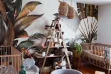 a jungle themed nursery with a printed leaf wall, rattan lamps, an elephant chair and a jute rug