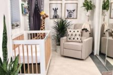 a jungle themed nursery with black and white artworks, potted plants, a light canopy and printed textiles