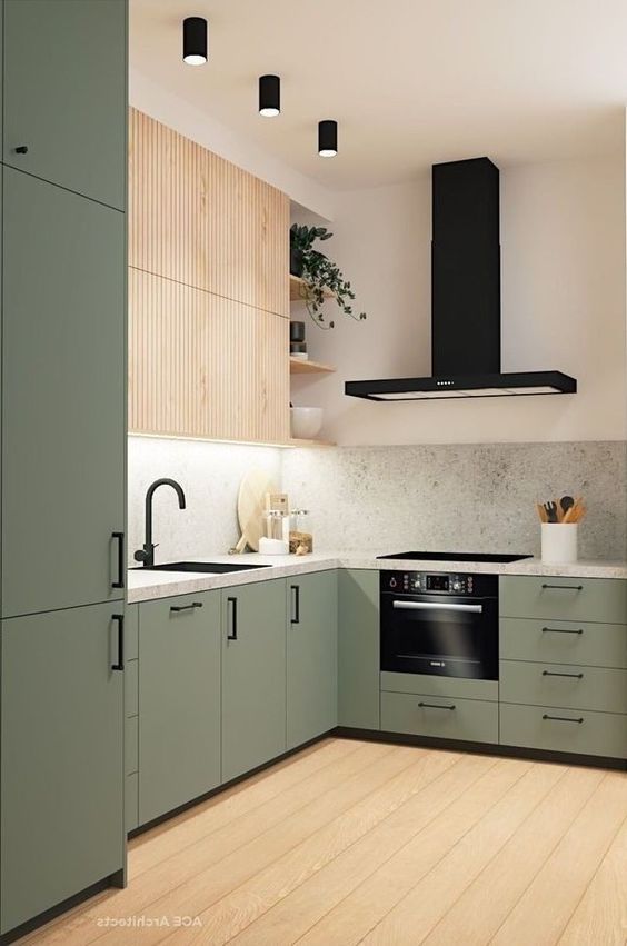 a laconic modern kitchen with fluted stained and light green cabinets, a stone backsplash and black handles
