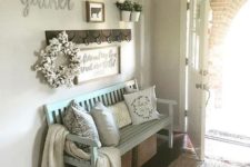 a light blue bench, some woven boxes for storage, pillows and a gallery wall for a cozy rustic feeling