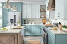 a lovely cottage kitchen with light blue and muted blue cabinets, a stained kitchen island and white stone countertops, pendant lamps