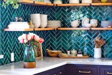 a midnight blue kitchen with only lower cabinets, white countertops, a teal herringbone tile backsplash and open shelves