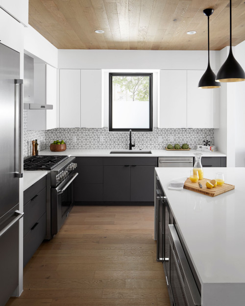 a modern black and white kitchen with sleek cabinets, a black frame kwindow, a geo tile backsplash and black pendant lamps (by Breathe Design Studio)