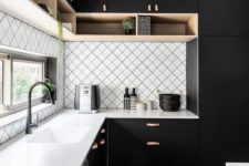 a modern black kitchen with a geometric backsplash and white countertops plus touches of wood