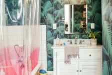 a modern bold tropical bathroom with dark tropical wallpaper, a pink clawfoot tub and a color block curtain, a vintage shutter vanity