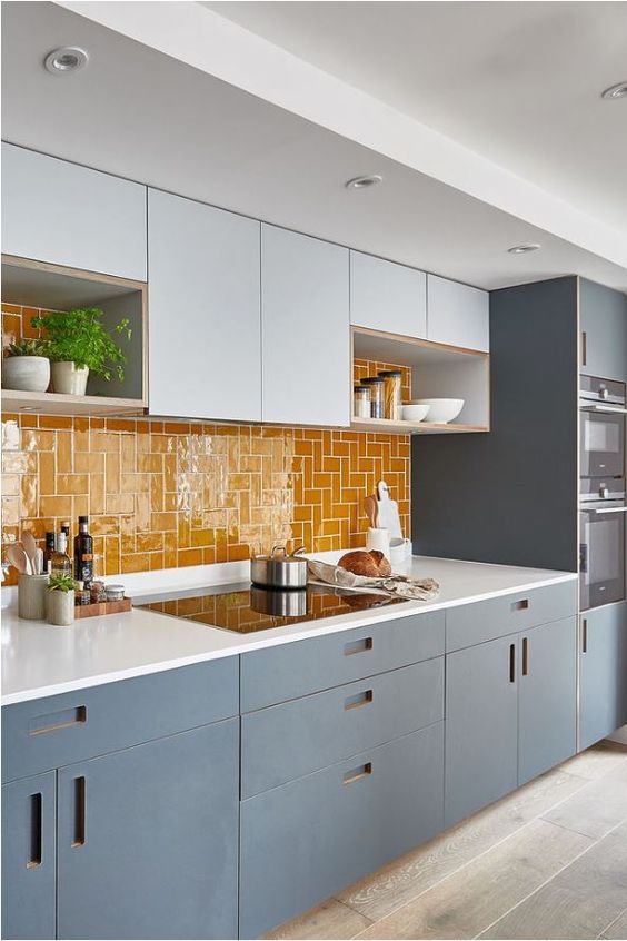 a modern grey and white kitchen with white countertops, a bold yellow tile backsplash is a super sleek and catchy idea
