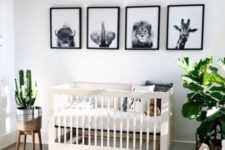 a modern tropical nursery with potted plants, bubble chandelier, black and white artworks and layered rugs