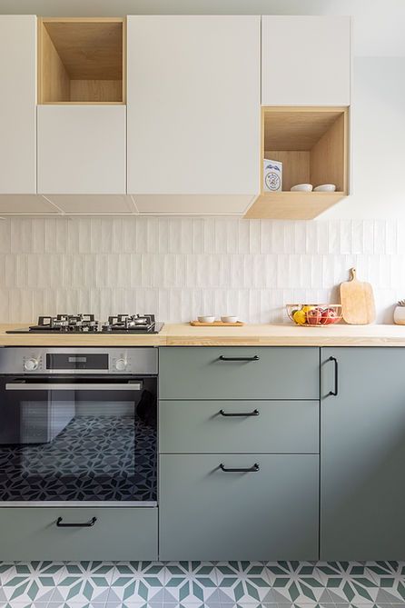 a modern two-tone kitchen with white skinny tiles, butcherblock countertops, black handles is a lovely space