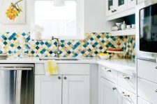 a modern white kitchen with a colorful arabesque tile backsplash that brings color and interest to the space