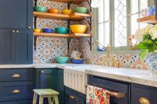 a navy kitchen island and extra bold printed tiles, open shelves, colorful dinnerware and some blooms