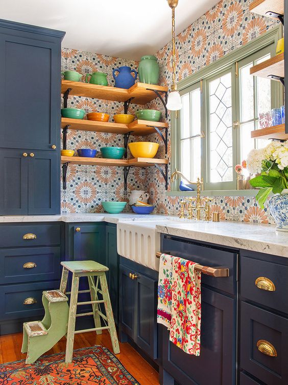 a navy kitchen island and extra bold printed tiles, open shelves, colorful dinnerware and some blooms