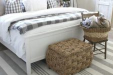 a neutral farmhouse space with a white bed, neutral bedding and buffalo check, baskets for storage and shades and curtains