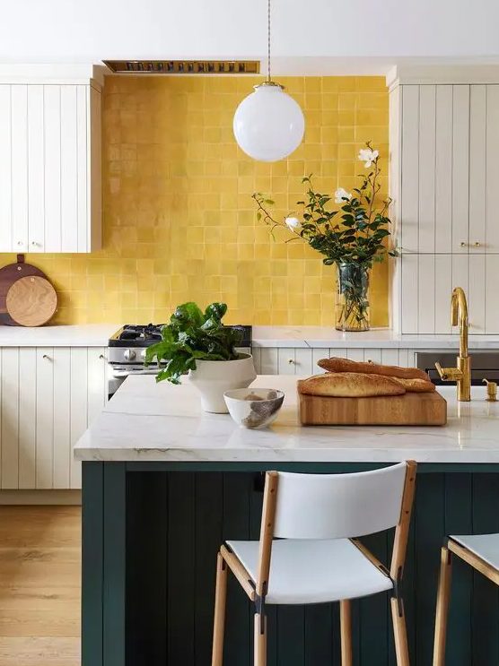 a neutral planked kitchen with a teal kitchen island and white stone countertops, a bold yellow tile backsplash is a very pretty idea