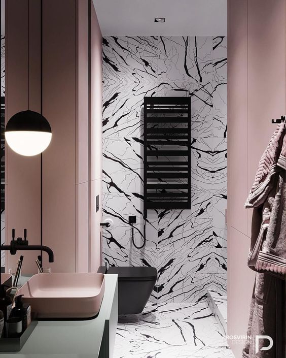 a quirky bathroom with blush walls and a sink, black and white tiles plus black fixtures for an ultra-modern look