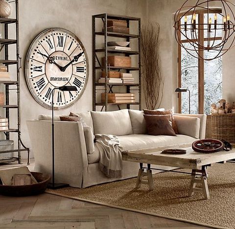 a rustic industrial living room with concrete walls, a wooden table, metal shelving units, a large clock and some metal gears