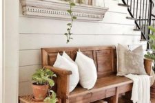 a simple farmhouse entryway with wooden furniture, a box, some wooden trays, greenery and a selection of bottles