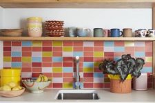 a stained kitchen with white countertops, a colorful tile backsplash and open shelves with colorful teaware