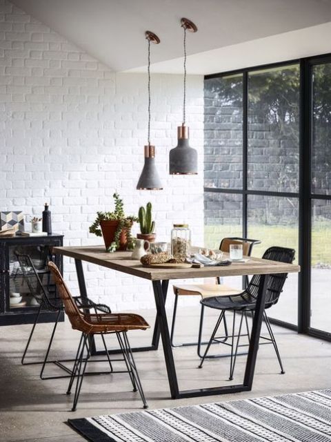a stylish contemporary dining room with white brick walls, grey and copper lamps, wicker chairs and a glazed wall