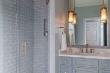 a traditional light-colored grey bathroom with subway and hex tiles, with a traditional vanity and touches of gold