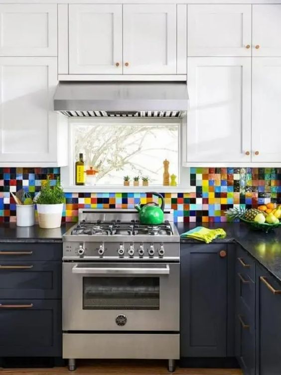 A two tone kitchen in navy and white, with black countertops and a colorful tile backsplash is adorable and cool