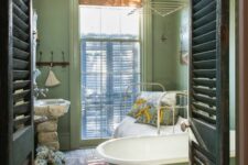 a vintage bathroom with light green walls, a printed rug, a clawfoot tub, a bed and a unique stone sink