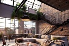 a welcoming and airy living room in industrial style, with brick walls, a metal and wood table, a leather ottoman and an L-shaped sofa plus greenery