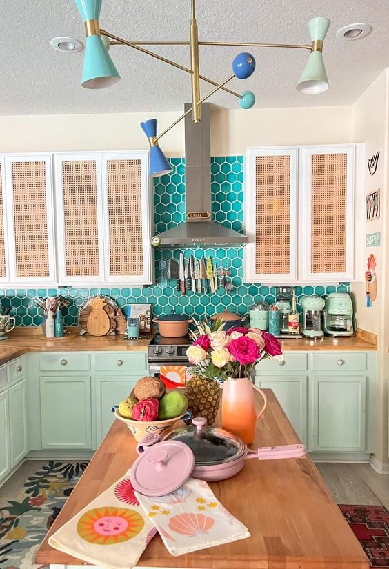 a whimsy kitchen with mint and cane cabinets, a turquoise hex tile backsplash and butcherblock countertops