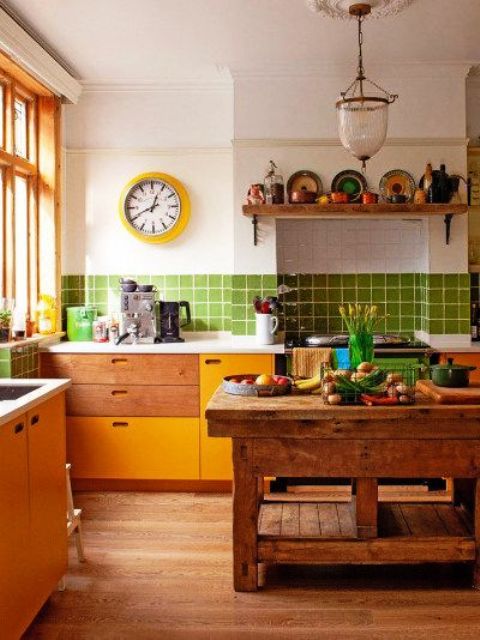 a whimsy kitchen with stained and yellow cabinets, a stained rough wood kitchen island, a bold green tile backsplash