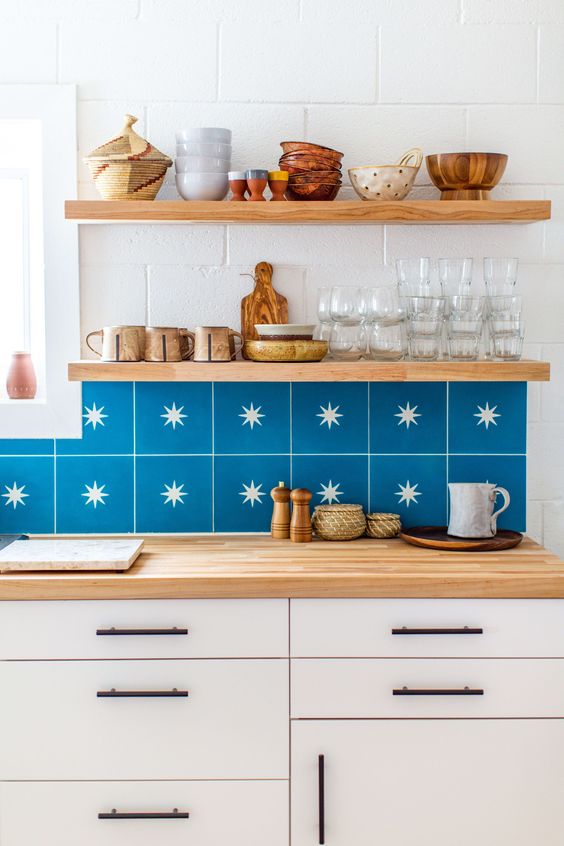a white Scandinavian kitchen with a bold blue star tile and open shelves plus butcherblock countertops is amazing
