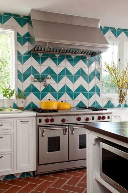 a white farmhouse kitchen with an extra bold chevron turquoise and white backsplash and stainless steel appliances