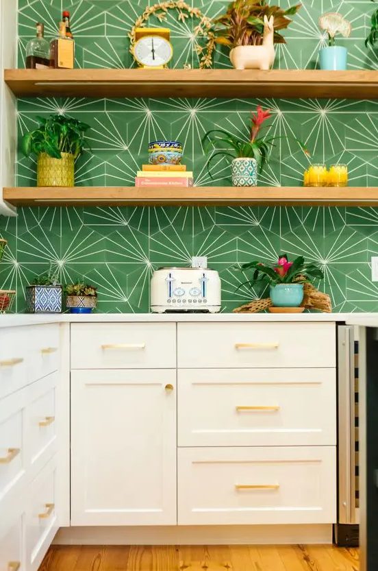 a white shaker kitchen with white stone countertops and a bold green geo print backsplash, open shelves and potted blooms and plants