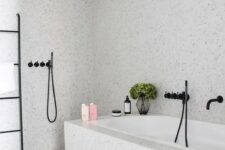 an airy and serene grey bathroom done with terrazzo, with black touches for a more modern feel