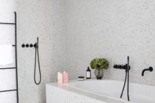 an airy and serene grey bathroom done with terrazzo, with black touches for a more modern feel