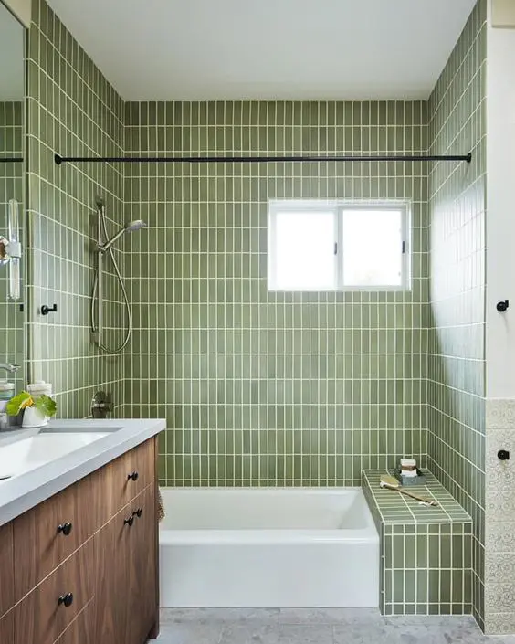 an airy bathroom with light green skinny tiles, a stained vanity, a window and a large mirror is a chic and cool space