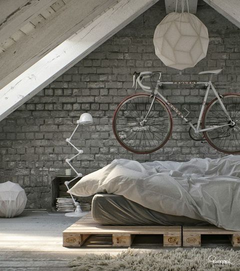 an attic industrial bedroom with grey brick walls, a pallet bed, a metal floor lamp and paper lamps