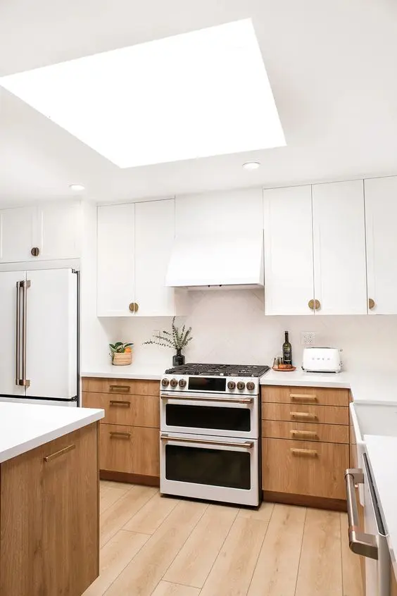 an elegant white and stained kitchen with white stone countertops and a white herringbone tile backsplash