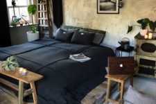 an industrial bedorom with shabby chic walls, a pallet bed, simple wooden furniture and dark bedding