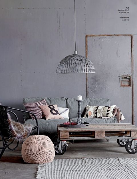 an industrial minimalist living room with concrete walls, a wooden floor, metal and wood furniture, a metal pendant lamp