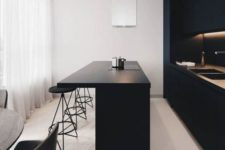 an ultra-minimalist kitchen with sleek black cabinets, built-in lights, a large kitchen island and a white hood